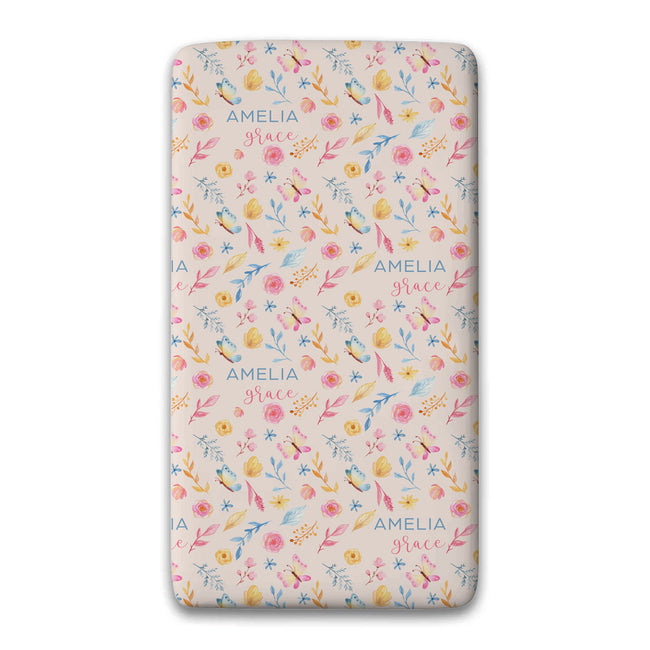 A personalized custom twin sheet with a floral pattern on a light pink background, featuring the name 'AMELIA' and the word 'Grace' printed repeatedly in blue. The sheet is shown flat against a white background with a soft drop shadow.