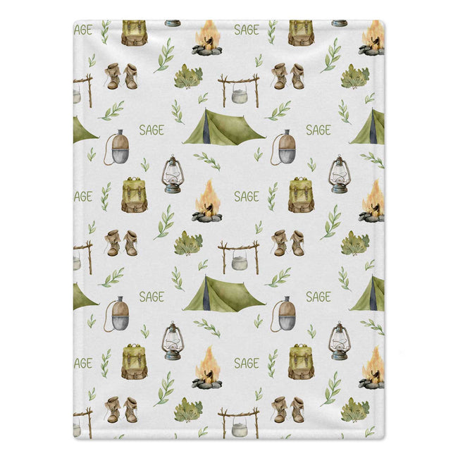 Personalized Camping Baby Blanket. Tents, campfires, lanterns, and outdoor adventure details surround a custom name in earthy woodland colors.
