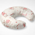A U-shaped baby nursing pillow with a cream-colored fabric printed with watercolor-style bunnies wearing pink hats, small pink polka dots, and the personalized name 'CHARLOTTE ann' in dark red script.