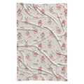 A personalized swaddle blanket with a repeating Christmas bunny pattern, featuring light brown rabbits in red Santa hats next to pink gift boxes on a warm off-white background.