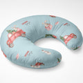 A U-shaped nursing pillow in light blue with a festive Christmas print featuring red vintage trucks carrying Christmas trees, snowmen, and the words 'Santa's nag' and 'Santa joy'.
