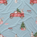 A light blue fabric with a festive Christmas print featuring red vintage pickup trucks carrying Christmas trees, snowmen, bunnies, and gift boxes. The text 'SIENNA rose' is printed on the fabric.