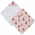 Blush pink hooded towel featuring decorated Christmas trees, presents, stars, bunnies in gift boxes, and the name Charlotte Anne.