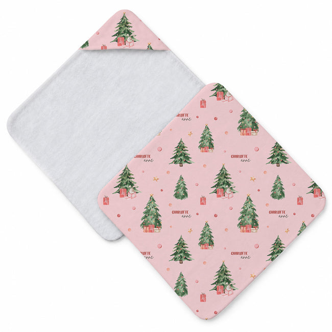 Blush pink hooded towel featuring decorated Christmas trees, presents, stars, bunnies in gift boxes, and the name Charlotte Anne.