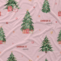 Pink fabric with a Christmas pattern featuring watercolor green trees, red and gold ornaments, wrapped presents, and the text 'CHARLOTTE annl'.