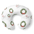 A white U-shaped nursing pillow featuring a repeating pattern of green holly wreaths with red bows and the name 'JACK wyatt' printed in brown script.