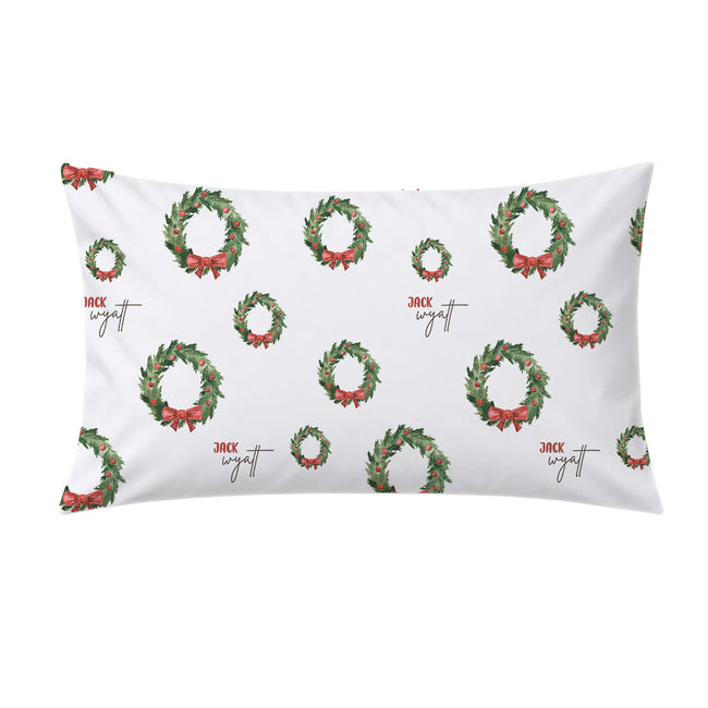 A white rectangular pillow sham featuring a repeating pattern of green Christmas wreaths with red bows and the name 'Jack' printed in a cursive font.