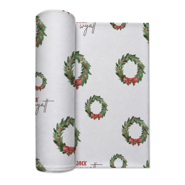 Personalized Christmas wreath swaddle blanket with evergreen branches, red bows and optional baby name