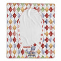 A square baby milestone blanket with a colorful harlequin diamond border and a large white oval center for writing months, decorated with a small juggling elephant at the bottom.