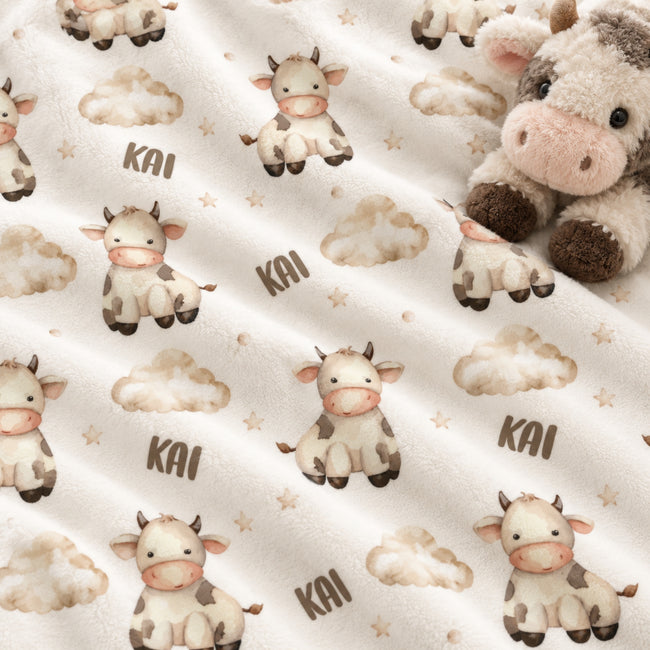 Personalized Cow Baby Blanket. Sweet cows and soft cloud details create a gentle countryside setting for a custom name.