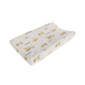 A contoured baby changing pad cover featuring a yellow construction vehicle and sailboat pattern on a light gray background, with the name 'MASON' printed repeatedly.