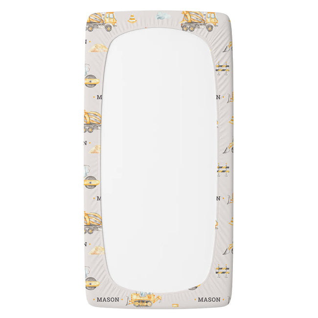 A fitted sheet featuring a light gray background with a repeating pattern of yellow construction vehicles and the name 'MASON' printed at the bottom.