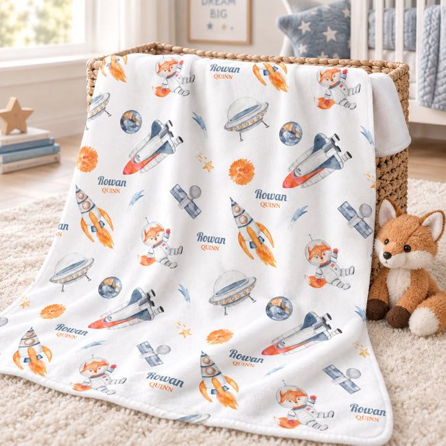 Personalized Space Fox Baby Blanket. An adventurous astronaut fox, rockets, and planets bring a playful little universe to a custom name.
