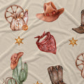 Western-themed fabric print featuring watercolor-style illustrations of cowboy hats, boots, a cactus with a hat, a money sack with a dollar sign, sheriff star badges, and a red bandana on a light beige background.