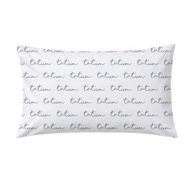 A rectangular white pillow case featuring a repeating pattern of the word 'tatum' in a dusty blue cursive script, shown against a plain white background.