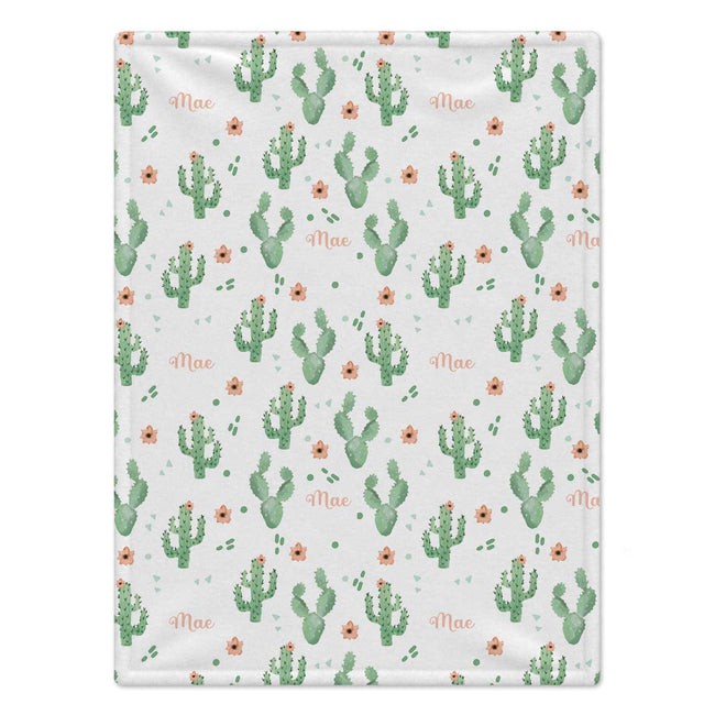 A rectangular blanket with a repeating pattern of green cacti, small orange flowers, and the name 'Mae' in peach script on a white background.