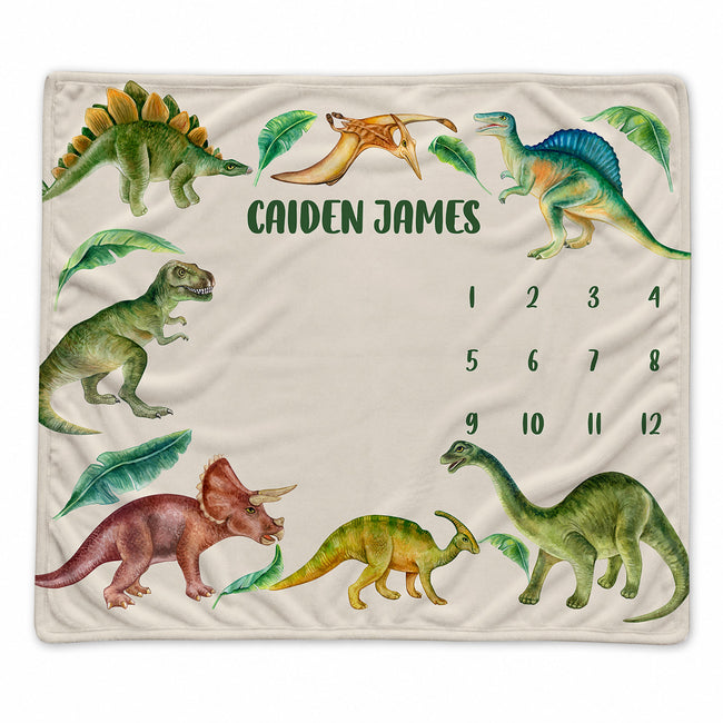 Personalized dinosaur baby milestone blanket with watercolor dinosaurs, tropical leaves, custom name, and months 1–12