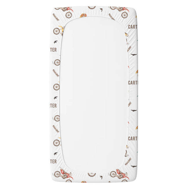A personalized twin sheet with a decorative border featuring vintage bicycle illustrations and the word 'Cartier' in brown.