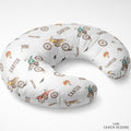 A U-shaped nursing pillow with a white background and a repeating pattern of dirt bikes, checkered flags, birds, and the name 'CARTER' in brown text. The brand 'CAIDEN DESIGNS' is visible in the bottom right corner.
