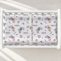 A white changing table with a personalized changing pad cover featuring dirt bike and motorcycle pattern printed with the name 'CARTER' in brown.