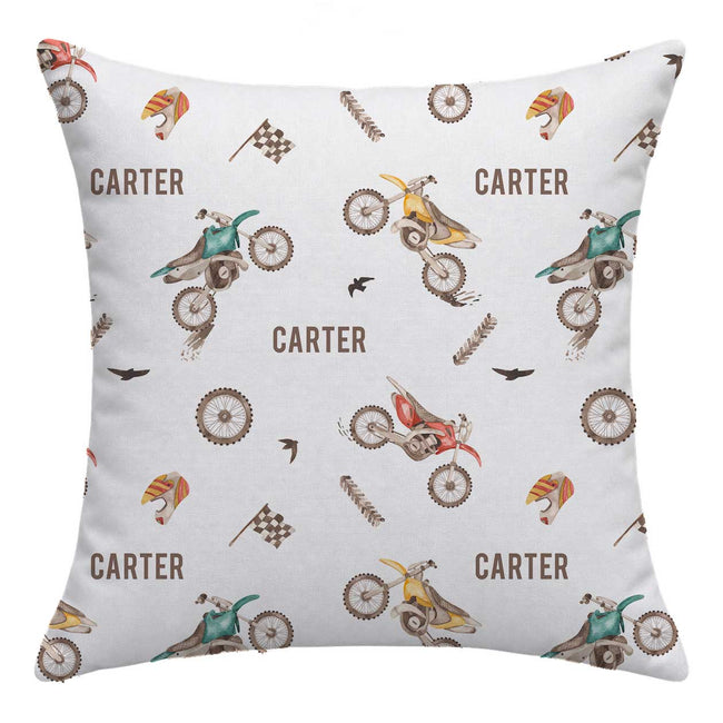 A square throw pillow featuring a repeating cartoon-style dirt bike and rider pattern with the name 'CARTER' printed across a light gray background.