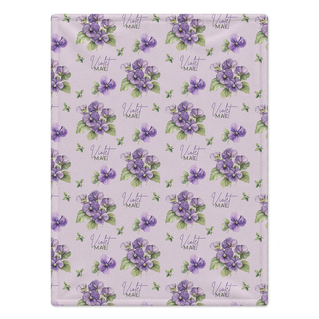 Pale lavender blanket with purple violet flowers, green leaves, and the name Violet Mae in purple script and green lettering.
