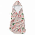 Pale blush hooded towel with pink flamingos, green tropical leaves, small flowers, and the name Leonor in coral script.