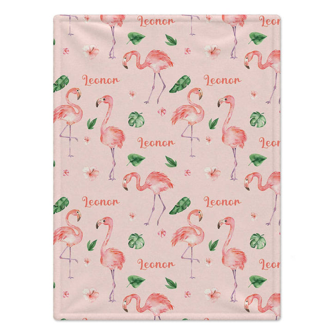 Personalized Flamingo Baby Girl Blanket. Playful flamingos and tropical greenery surround a custom name on a cheerful pink background.