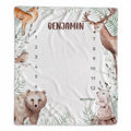 A personalized baby monthly milestone blanket featuring woodland animal illustrations including a deer, bear, rabbit, bird, fox, and leaves. The center is blanked out with the name 'BENJAMIN' and columns for 1 through 12 months with the label 'MONTHS'.