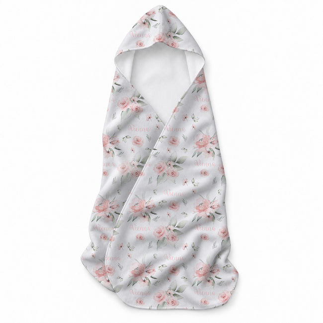 A baby towel with a hood, featuring a delicate pink and green floral pattern on a white background with faint 'Vienna' text.