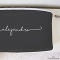 A personalized grey changing pad featuring the name "Alejandro" in a white cursive font.