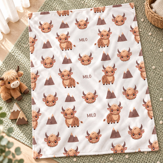 Personalized Highland Cow Baby Blanket. Fluffy highland cows and warm earthy details surround a custom name in a charming rustic design.