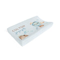A personalized changing pad cover in white with a watercolor hot air balloon design and the names 'COLTON joseph' printed on the front, shown on a clean white background.