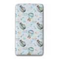 A twin fitted sheet, featuring a light blue background with a repeating pattern of watercolor hot air balloons, stars, clouds, and the personalized name 'COLTON joseph' in brown and blue.