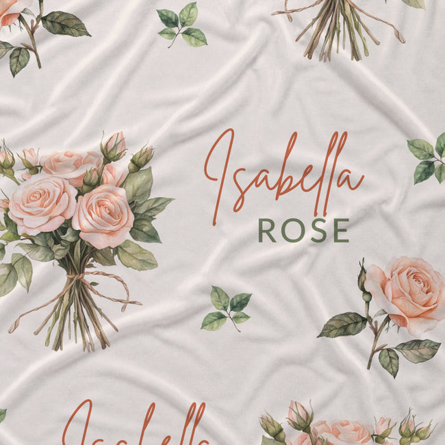 Ivory fabric with peach rose bouquets, scattered green leaves, and the name Isabella Rose in coral and green lettering.