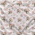 Ivory swaddle blanket with peach rose bouquets, scattered green leaves, and the name Isabella Rose in coral and green lettering.