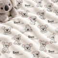 A close-up of a soft fleece blanket with an allover print of koala illustrations and the names 'Knox' and 'William' in black script. A plush koala toy is partially visible in the top left corner.