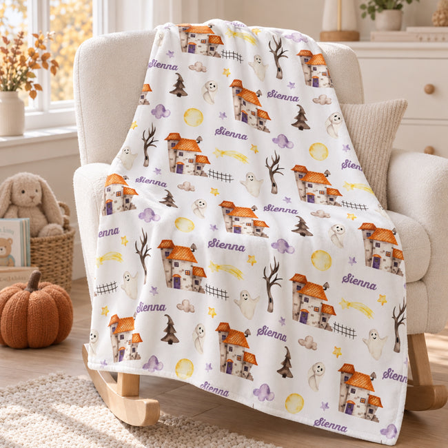 Personalized Halloween Baby Blanket. Playful Halloween characters and cheerful seasonal details surround a custom name in a festive design.