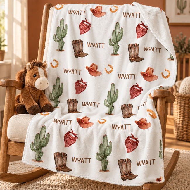 Personalized Cowboy Baby Boy Blanket. Cowboy hats, boots, bandanas, and cacti bring warm western charm to a custom name.