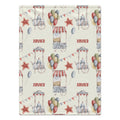 A personalized blanket featuring a vintage fairground pattern with red and blue watercolor-style tents, balloons, stars, bunting, and the name 'XAVIER' repeated in red on an off-white background.