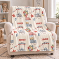 A personalized baby nursery accent chair draped with a cream-colored fleece blanket featuring a colorful carnival print and the name 'XAVIER' repeated in red.
