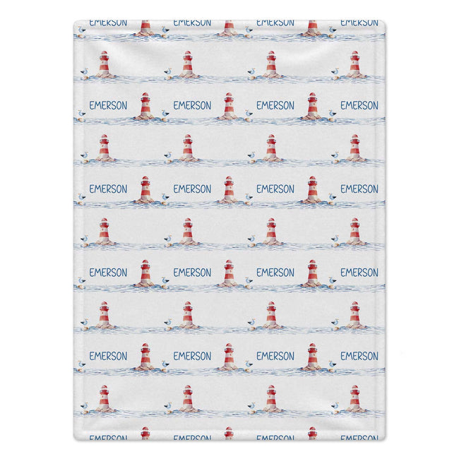 Personalized Lighthouse Baby Blanket. Red-and-white lighthouses, little seabirds, and blue watercolor waves create a coastal setting for a custom name.