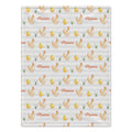 A rectangular fabric item, likely a baby blanket or towel, featuring a repeating pattern of watercolor-style chickens, yellow chicks, green grass, and the name 'Maisie' in orange script on a light gray and white striped background.