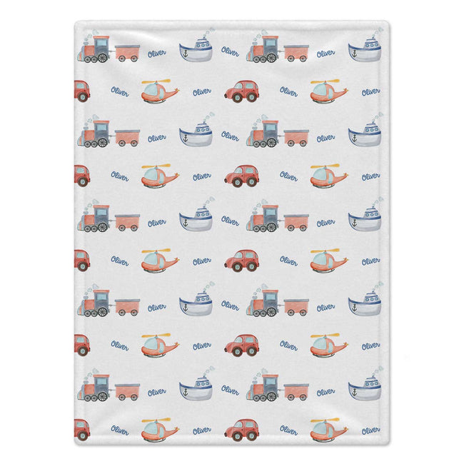 A rectangular baby blanket with a repeating pattern of various vehicles (trains, cars, boats, helicopters) in muted red, blue, and gray tones on a white background.
