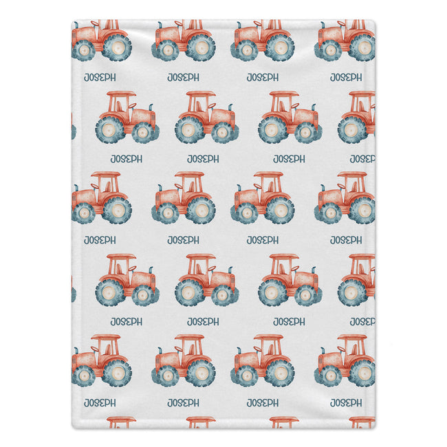 Personalized Tractor Baby Blanket. Coral watercolor tractors with blue wheels surround a custom name on a white background.