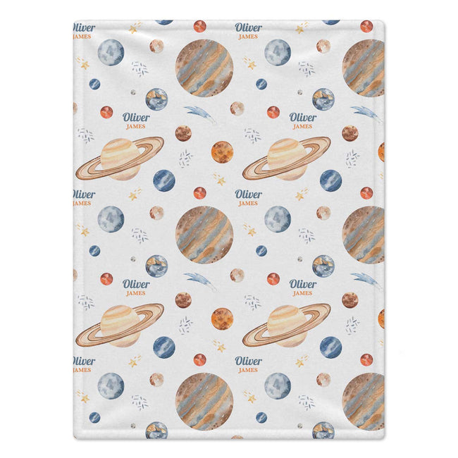 A personalized baby blanket featuring a space-themed pattern with planets, stars, and the names 'Oliver James' printed in blue and orange, set against a clean white background.