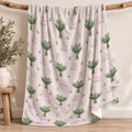 Pale blush blanket with white lily of the valley bouquets, green leaves, and the name Lillian Grace in rose and green lettering.