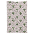 Pale blush swaddle blanket with white lily of the valley bouquets, green leaves, and the name Lillian Grace in rose and green.