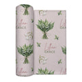 Pale blush swaddle blanket with white lily of the valley bouquets, green leaves, and the name Lillian Grace in rose and green.