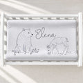 A personalized baby changing pad cover featuring a gray and white illustration of a polar bear, a deer, and the name 'Elena' in script.